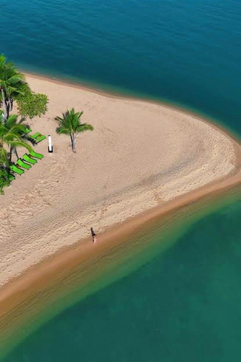 An empty Koh Samui sandbar with turquoise water and a single sunbather